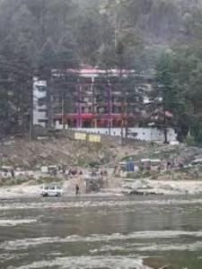 a white truck parked in front of a building at Hotel Saryal , Kullu in Kulu