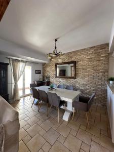 une salle à manger avec un mur en briques, une table et des chaises dans l'établissement Han’s Maisonette, à Porto Heli