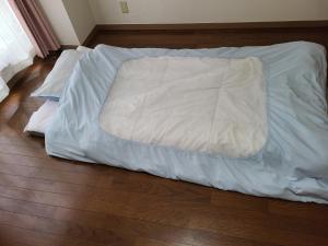 Un pat sau paturi într-o cameră la ホテルサンクリスタ4階