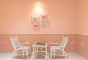 a room with three chairs and a table and a wall at Jaipur Bungalow in Jaipur