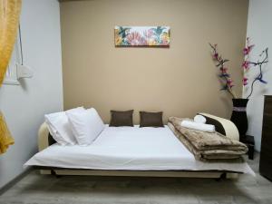 a bed with white sheets and pillows in a room at Perikleous Apartment in Xanthi
