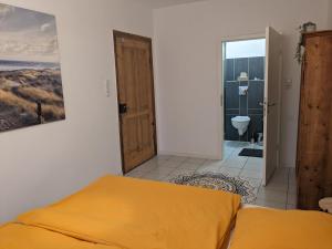 a bedroom with a bed and a bathroom with a toilet at zum runden Turm in Andernach