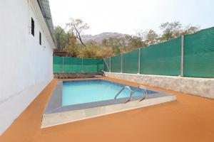 una piscina en la azotea de una casa en OYO A J Mountain View Cottage, en Lonavala