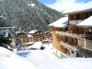 een resort met besneeuwde gebouwen en een skilift bij Chalet De Florence - Studio pour 4 Personnes 894 in Modane