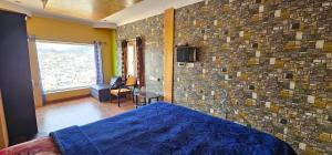 um quarto com uma parede de tijolos e uma cama em OOTY STAY AWHILE em Ooty
