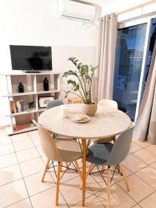 d'une table à manger avec des chaises et une plante. dans l'établissement Zenios Andromeda - Quiet and modern apartment, à Athènes