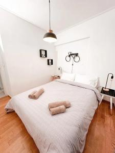 - une chambre avec un grand lit blanc et 2 serviettes dans l'établissement Zenios Andromeda - Quiet and modern apartment, à Athènes