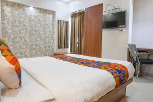 a hotel room with a bed and a television at FabHotel Emersion Residency in Pune