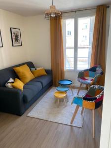 ein Wohnzimmer mit einem blauen Sofa und Stühlen in der Unterkunft Home concept Gace 1 - Superb apartment in Gacé in Gacé