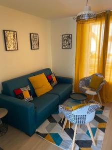 a living room with a blue couch and a table at Home concept Gace 1 - Superb apartment in Gacé in Gacé