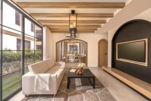 a living room with a tv and a couch and a table at The Residence Resort & Villas Phu Quoc in Phu Quoc