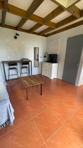 a living room with a table and a kitchen at La Petite Kaz Dans la Savane in Fleurimont