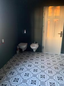 a bathroom with a sink and a toilet and a door at House of silence 