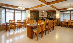 a dining room with wooden tables and chairs at Treebo Trend Eeshan Rodhi Resort - Darjeeling in Darjeeling