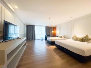 Habitación de hotel con 2 camas y TV de pantalla plana. en A-ONE Bangkok Hotel, en Bangkok