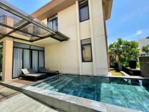 a swimming pool in front of a house at Big Star Villas - Wyndham Garden in Cam Ranh