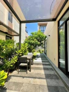 a patio with a table and chairs in a building at Big Star Villas - Wyndham Garden in Cam Ranh