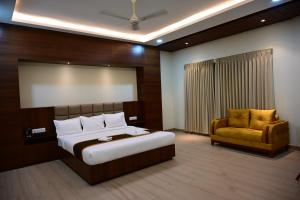 Pokój hotelowy z łóżkiem i krzesłem w obiekcie Unnati Stay Inn w mieście Vijapura