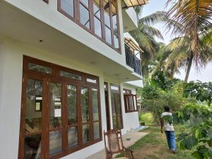 a person standing outside of a house at Villa paddy feild in Hiripitiya