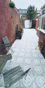 a patio with two benches and a brick wall at Lovely city town house with free parking sleeps 2 to 6 guests in York