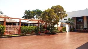 a building with a courtyard with trees and plants at Sai International Hotel in Dāvangere