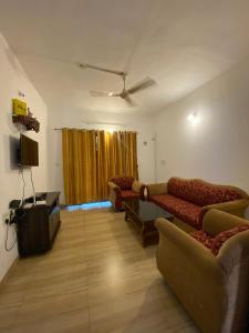 a living room with two couches and a tv at Apricot BH6 in Marmagao