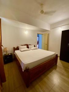 a bedroom with a large bed with white sheets at Apricot BH6 in Marmagao