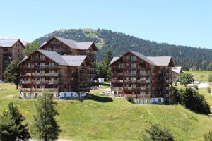 a group of apartment buildings on a hill with trees at Les Chalets De Superd Ancolie - 3 Pièces pour 10 Personnes 324 in Le Dévoluy