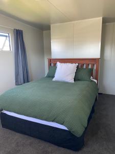 En eller flere senge i et værelse på Cute little Foxton Beach bach