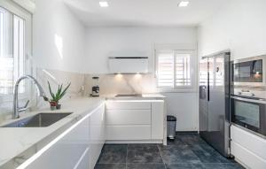 a white kitchen with a sink and a refrigerator at Gorgeous Home In Chiclana De La Fronter in Chiclana de la Frontera