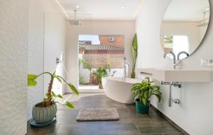 a bathroom with a tub and plants in it at Gorgeous Home In Chiclana De La Fronter in Chiclana de la Frontera +23 photos