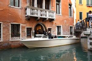 una barca in acqua di fronte a un edificio di Aqua Palace a Venezia