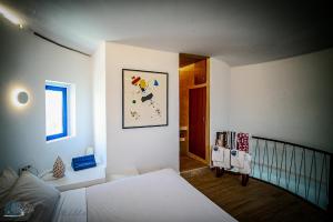 sypialnia z łóżkiem oraz korytarz ze schodami w obiekcie Zen Blue Mills w mieście Koundouros