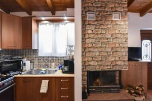 een keuken met een stenen muur en een open haard bij Το πατρικό του Σταύρου. in Mouzákion
