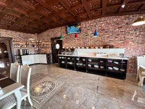 a kitchen with a brick wall and a table and chairs at Starway Hotel in Lankaran