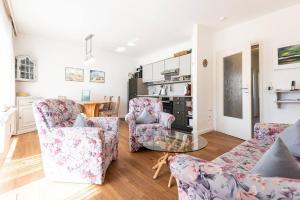 a living room with two chairs and a glass table at Sonnige Ferien im Nordseegruß 2 in Wenningstedt