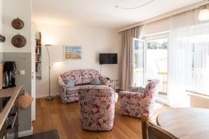 a living room with a couch and two chairs at Sonnige Ferien im Nordseegruß 2 in Wenningstedt