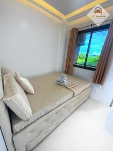 Cama pequeña en habitación con ventana en GTC Apartelle en Tacloban