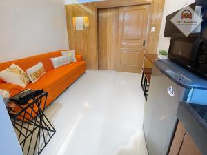un soggiorno con divano arancione di fronte a una porta di GTC Apartelle a Tacloban