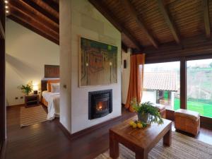 a living room with a fireplace and a bedroom at La Corte de Lugás in Lugás