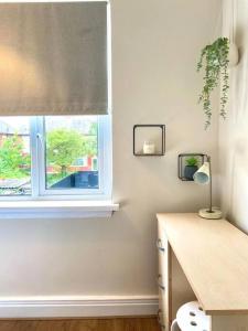 Zimmer mit einem Fenster und einem Schreibtisch mit einer Lampe in der Unterkunft Spacious, garden, Netflix, near city in Newcastle upon Tyne