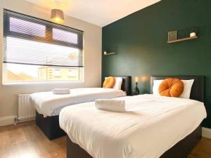 2 Betten in einem Zimmer mit grüner Wand in der Unterkunft Spacious, garden, Netflix, near city in Newcastle upon Tyne