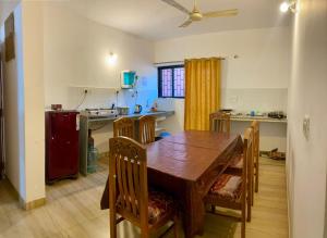 a kitchen with a wooden table and a dining room at Apricot BH6 in Marmagao
