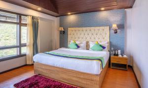 Postel nebo postele na pokoji v ubytování Treebo Eeshan Rodhi Resort, Darjeeling