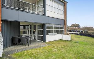a building with a table and chairs next to a train at 2 Bedroom Nice Apartment In Fan in Fanø