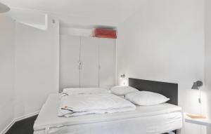 um quarto branco com uma cama com lençóis e almofadas brancos em 2 Bedroom Nice Apartment In Fan em Fanø