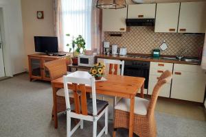 a kitchen with a wooden table with chairs and a kitchen at Gemütliche Ferienwohnung am Wildgehege in Walsrode