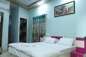 a bedroom with a large white bed and a window at Radhe Radhe Guest House in Dehradun