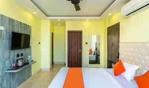 a bedroom with a large bed with an orange blanket at FabHotel Aspiring Inn in Kolkata