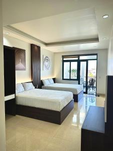 a bedroom with two beds and a large window at TaMaDu's House in Ha Long